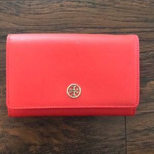 Red Tory Burch clutch with detachable strap.